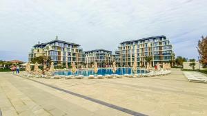 a row of apartment buildings with a pool and chairs at Квартира в SEEBREZE in Nardaran
