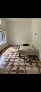 a bedroom with a bed in the corner of a room at Himanshu in Jalālpur Dhai