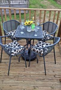 una mesa con 2 sillas y copas de vino en una terraza en Blue Water Retreat, en Dawlish Warren 22 fotos más