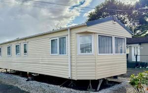 uma pequena casa está estacionada num quintal em Deluxe Delta 4-Bedroom Caravan Located at Maryville Caravan Site Uddingston, Glasgow em Uddingston
