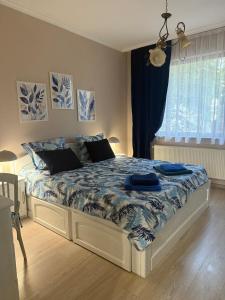a bedroom with a bed with blue sheets and a window at Cozy apartment in Haskovo