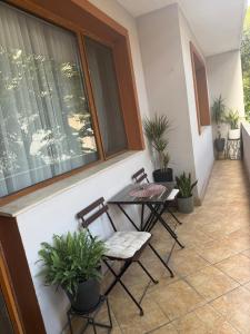 a porch with two chairs and a table and plants at Cozy apartment in Haskovo