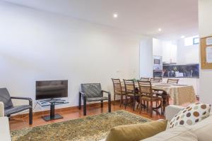 ein Wohnzimmer mit einem Tisch, Stühlen und einem TV in der Unterkunft Home17 in Porto