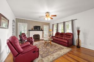 a living room with red chairs and a table at Southern Porch Life in Ocala