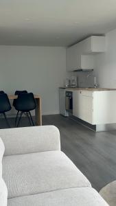 a living room with a white couch and a kitchen at Apartment in Ilulissat - by Pilu & Kaali in Ilulissat +8 photos