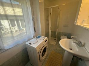 a bathroom with a toilet and a sink and a shower at Calle Coppo appartamento nel centro storico - Agenzia Cocal in Caorle +1 photo