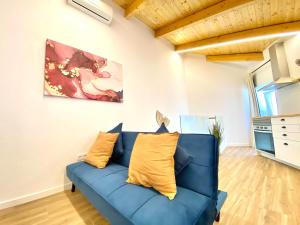 un divano blu in un soggiorno con un dipinto di Flor-The Cozy apartment in Lagoa a Lagoa Altre 20 foto