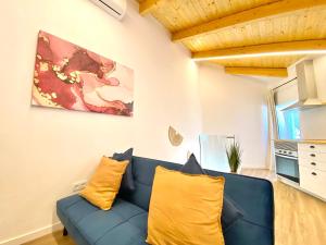 un soggiorno con divano blu e cuscini gialli di Flor-The Cozy apartment in Lagoa a Lagoa