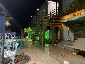 a patio with a wooden staircase and a pool at night at Pousada Jolie Maison in São Francisco do Sul
