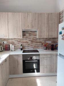 a kitchen with wooden cabinets and a stove top oven at Casa Linda in Monte Pego