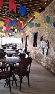 a restaurant with tables and chairs and colorful flags at Flat Divina Paz Monte Castelo in Sairé