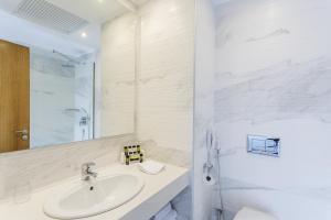 a white bathroom with a sink and a shower at Ibiscus Hotel in Rhodes Town