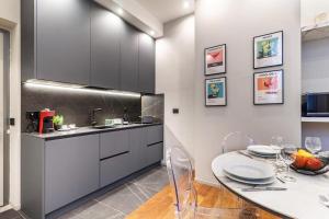 a kitchen with a table with chairs and a sink at luxury house - como lake in Como +13 photos