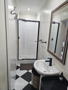 a bathroom with a sink and a shower with a mirror at The Rose Cottage in Hilton