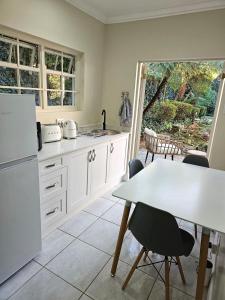a kitchen with a table and a white refrigerator at The Rose Cottage in Hilton