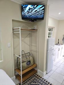 a room with a television on a wall with a closet at The Rose Cottage in Hilton