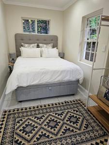 a bedroom with a large bed with white sheets and a rug at The Rose Cottage in Hilton