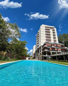 a swimming pool in front of a building at Apartamento en Luque cerca de Asunción 110 in Luque