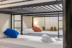 a bedroom with two bunk beds and a living room at Carmen Beach Hostel Cullera in Cullera