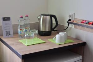a counter with two bottles of water and a kettle at Hotel Venatus in Zalaegerszeg