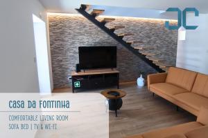 a living room with a tv and a staircase at Casa da Fontinha - Swimming Pool & Free Parking 
