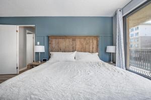 une chambre avec un grand lit et une grande fenêtre dans l'établissement YYC HiddenGem, à Calgary