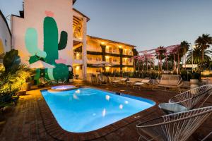 a pool in front of a hotel with chairs and a building at Beach House by ULIV in Ensenada