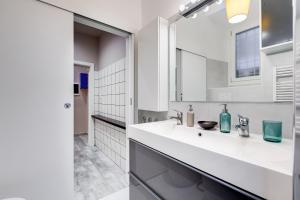 a white bathroom with a sink and a mirror at LuxurySistersHouse 2 min Colosseum in Rome +18 photos