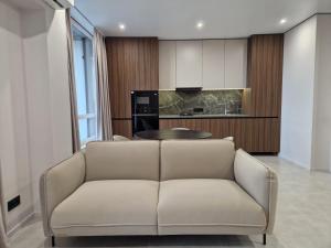 a living room with a couch and a kitchen at ApartReserve Avtorskiy Aparthotel in Ivano-Frankivsk