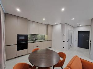 a kitchen with a wooden table and chairs in a room at ApartReserve Avtorskiy Aparthotel in Ivano-Frankivsk