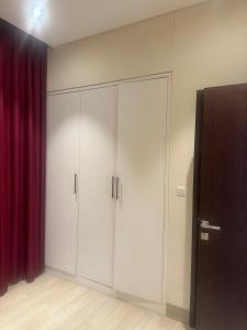 Una habitación con armarios blancos y una cortina roja. en Hawana salalah, en Salalah 3 fotos más