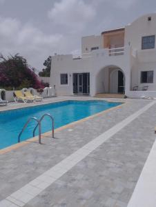 a villa with a swimming pool in front of a house at Villa Sandrella Tazdaine in Temlale
