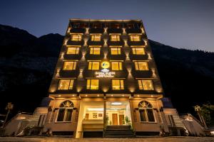 a hotel building with lights in the night at Tripli Hotels Ganga Heaven Rishikesh - Laxman Jhula in Rishīkesh