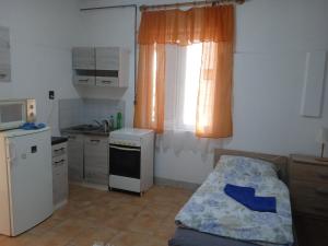 a small kitchen with a bed in a room at Szilasi Vendégház Apartman2 in Tüskevár