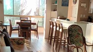 a kitchen and dining room with a table and chairs at Sossego e Conforto à Beira Mar in Capão da Canoa +9 photos