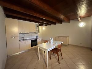 a kitchen with a white table and some chairs at Le due torri in Lecce neʼ Marsi