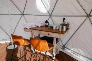 un tavolo di legno in una yurta con due sedie di Splitrock - Crown View Dome a Fallbrook