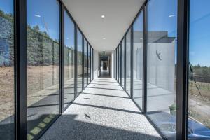 a hallway of glass walls in a house at Swiss Agricultural School Caucasus in Sarkinetʼi
