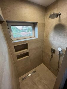 a bathroom with a shower with a window at Apartments Natasa in Supetar