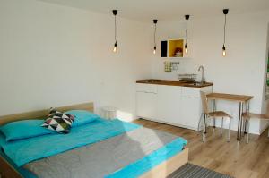 a bedroom with a bed and a table and a kitchen at Apartments 57 in Portorož