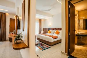 a hotel room with a bed and a bathroom at Tripli Hotels Ganga Heaven Rishikesh - Laxman Jhula in Rishīkesh +56 photos