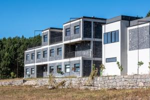 an apartment building on a hill with a stone wall at Swiss Agricultural School Caucasus in Sarkinetʼi