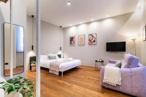 a bedroom with a bed and a couch and a tv at luxury house - como lake in Como