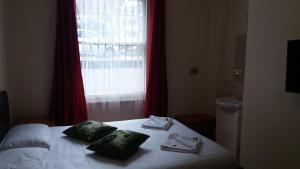 a bedroom with a bed with towels and a window at Kensington and Chelsea grand apartment in London