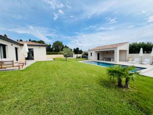 a yard with a pool and a house at la maison Sapanomar in Beaumes-de-Venise