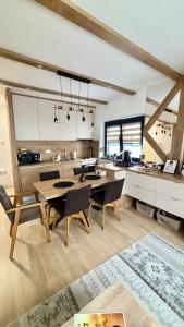 a kitchen and dining room with a table and chairs at Triple Shine Apartment Bjelašnica in Bjelašnica