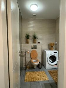 Un baño con inodoro y lavadora. en Apartament in Bucuresti, en Bucarest