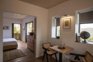 a bedroom with a bed and a desk and a table at Ecodomaine & Distillerie U Viaghju in Muro