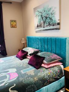 a bedroom with a blue bed with purple pillows at Super King, Close to Beach, Shops, Train, Shared Bathroom in St. Leonards