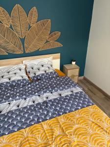 ein Schlafzimmer mit einem Bett mit einer blauen und goldenen Decke in der Unterkunft Chambre privé climatisé in Vertaizon